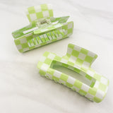 Checkmate Lilac Clip: a 3.6-inch glossy green checkered claw clip with a hinge closure, perfect for styling and keeping hair in place.