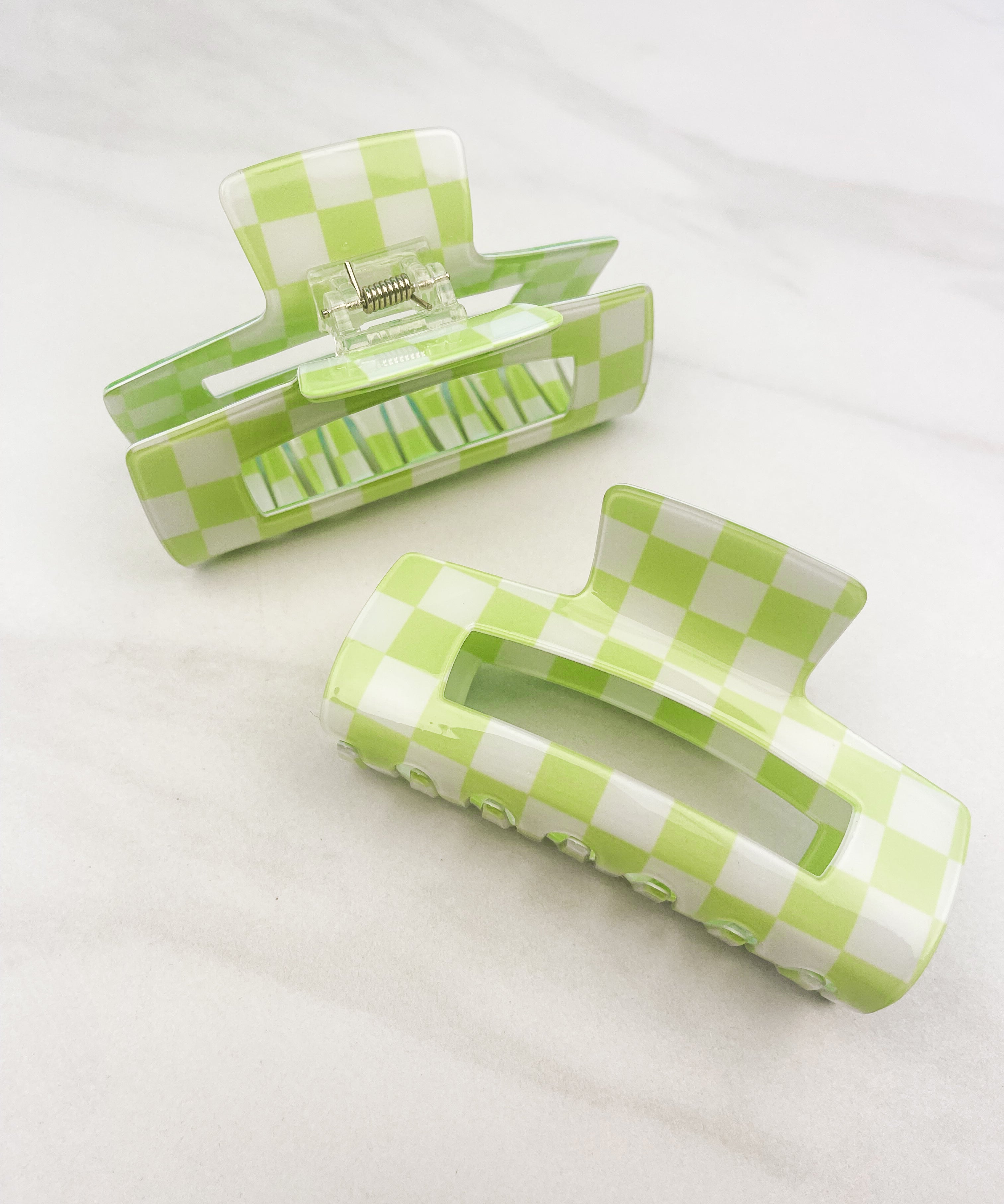 Checkmate Lilac Clip: a 3.6-inch glossy green checkered claw clip with a hinge closure, perfect for styling and keeping hair in place.
