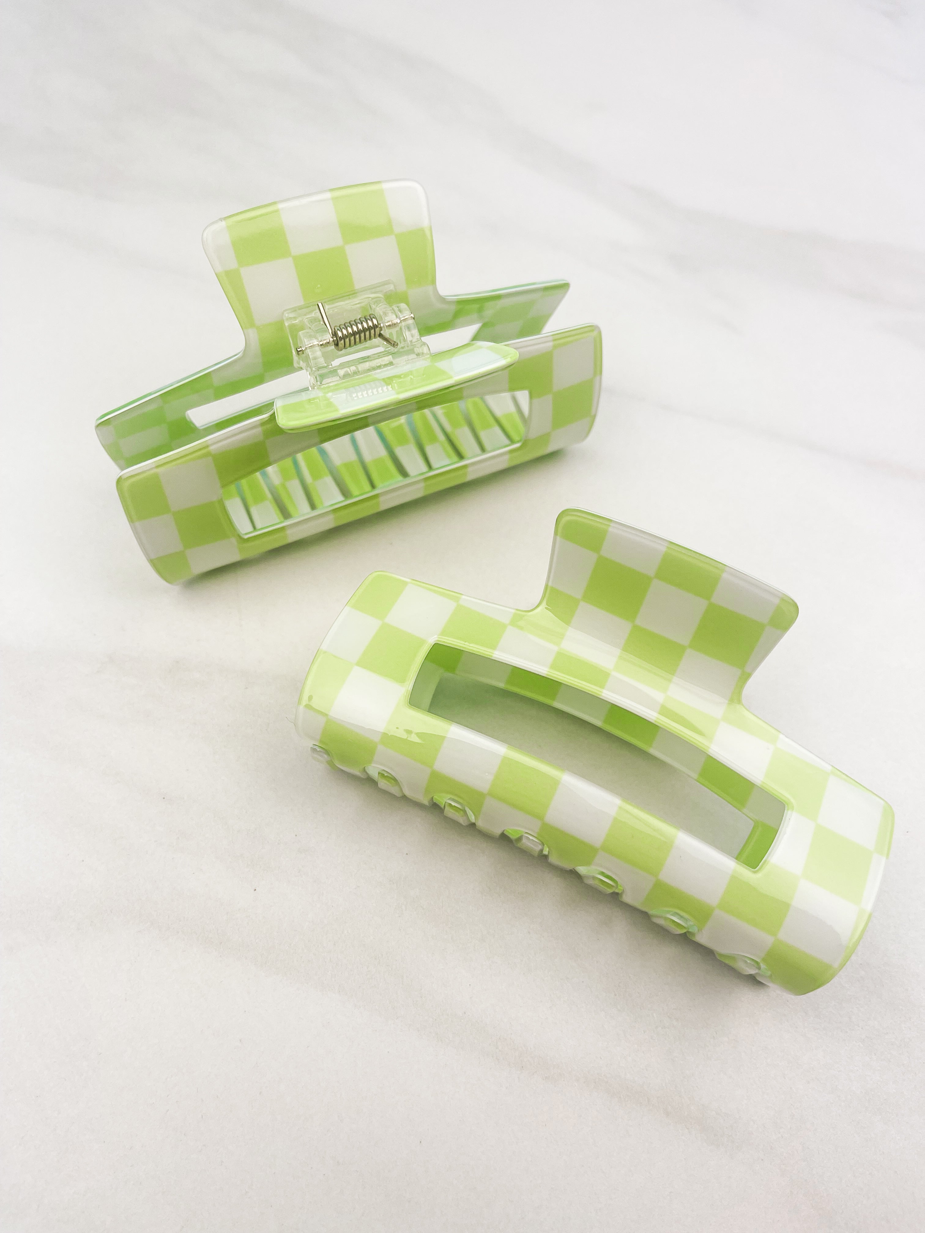 Checkmate Lilac Clip: a 3.6-inch glossy green checkered claw clip with a hinge closure, perfect for styling and keeping hair in place.
