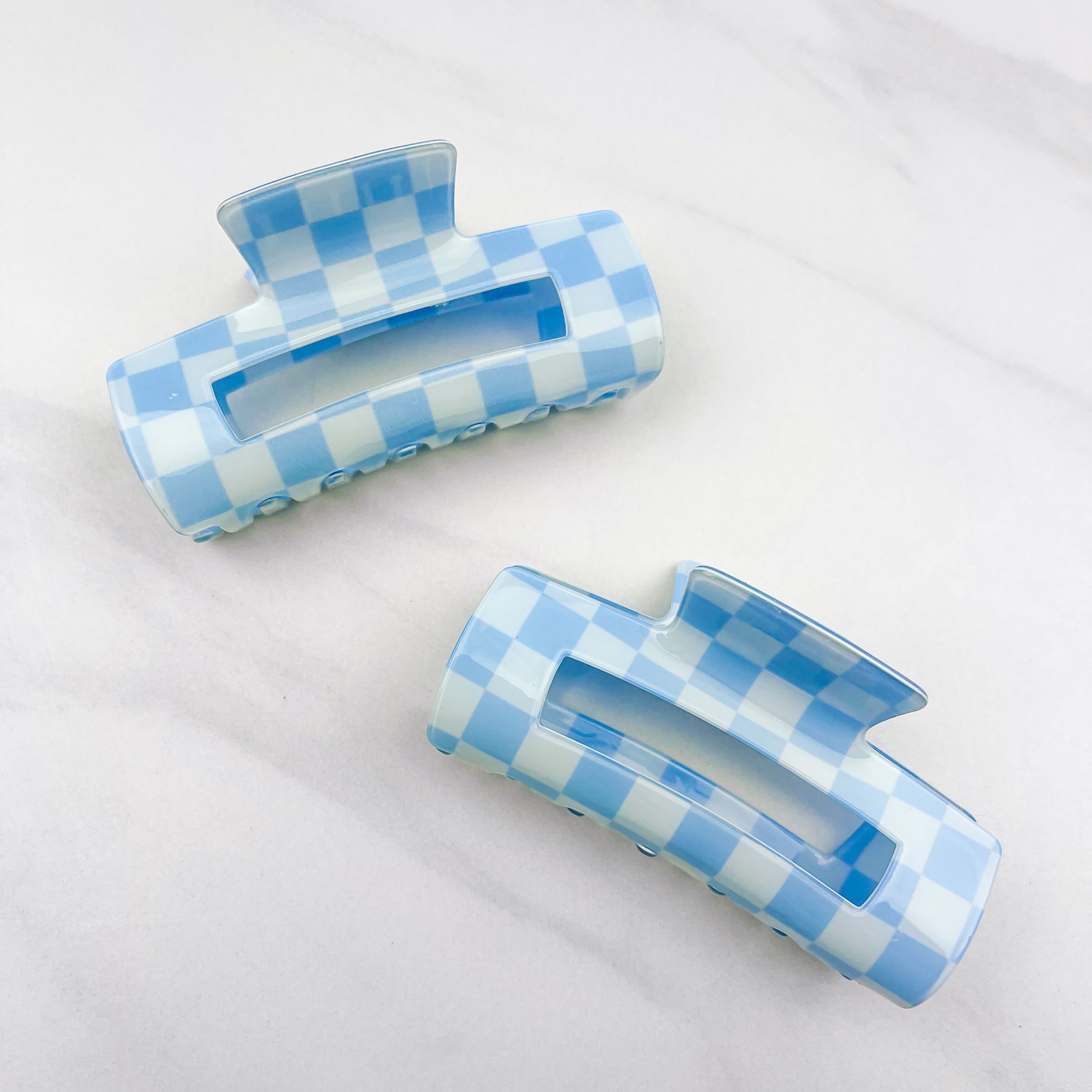 Checkmate Lilac Clip: a 3.6-inch glossy blue checkered claw clip with a hinge closure, perfect for styling and keeping hair in place.