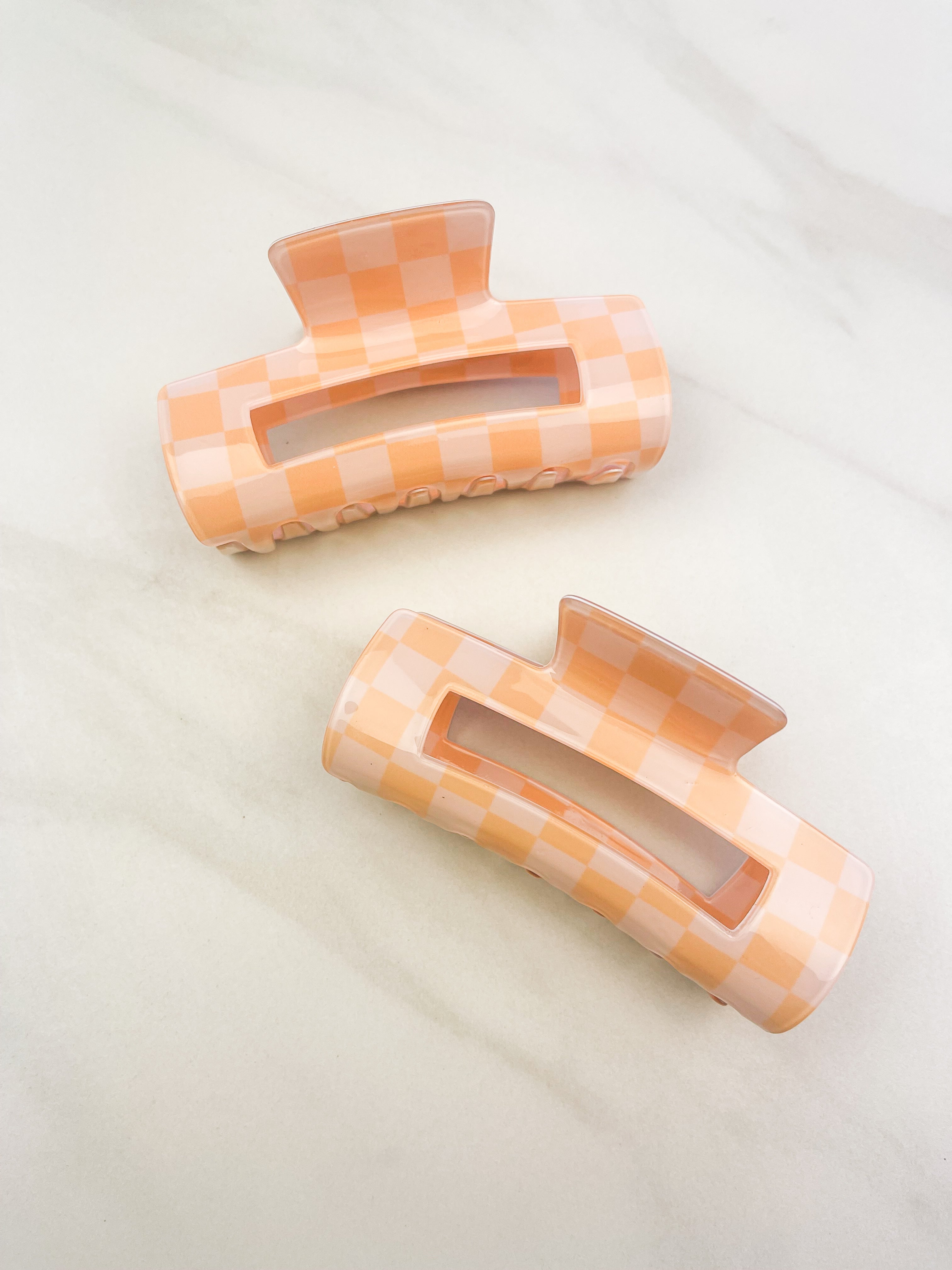 Checkmate Lilac Clip: a 3.6-inch glossy orange checkered claw clip with a hinge closure, perfect for styling and keeping hair in place.