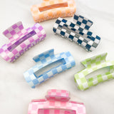 Checkmate Lilac Clip: a 3.6-inch glossy checkered claw clip with a hinge closure, perfect for styling and keeping hair in place.