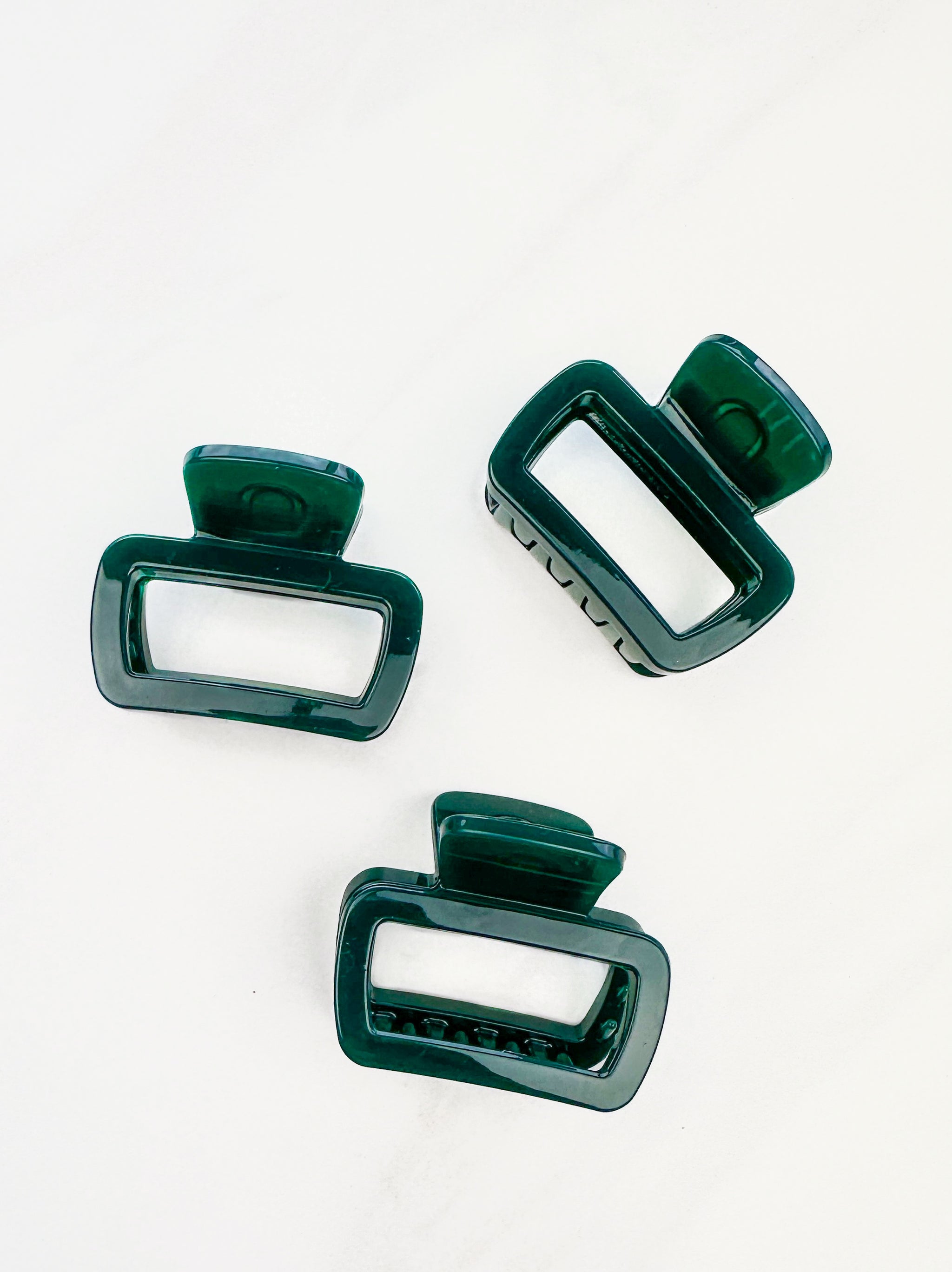 A close-up of a emerald Happy Hour Lilac Clip, a glossy hair accessory with a hinge closure, perfect for all hair types. 1.8 inches long.