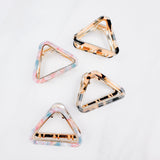 A group of Endless Weekend Lilac Clips, triangle-shaped hair accessory, perfect for all hair types. Glossy finish, 1.9 inches long, hinge closure.
