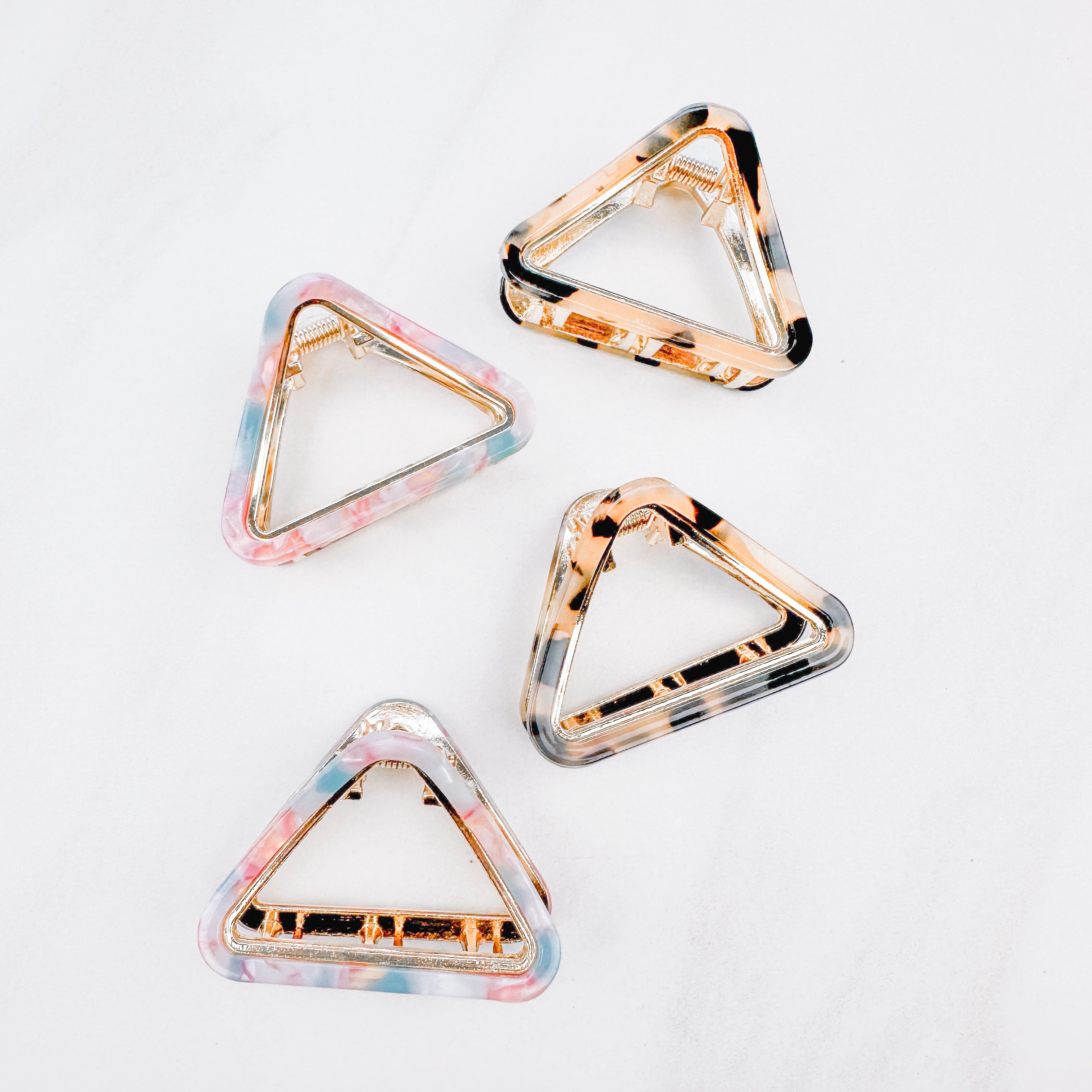 A group of Endless Weekend Lilac Clips, triangle-shaped hair accessory, perfect for all hair types. Glossy finish, 1.9 inches long, hinge closure.