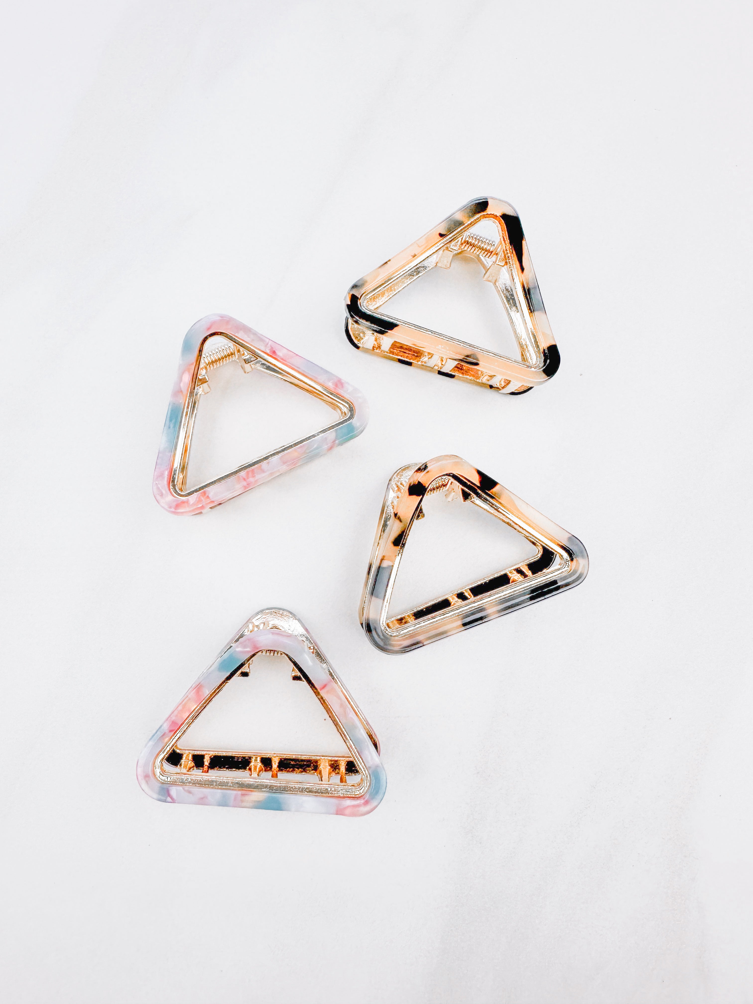A group of Endless Weekend Lilac Clips, triangle-shaped hair accessory, perfect for all hair types. Glossy finish, 1.9 inches long, hinge closure.