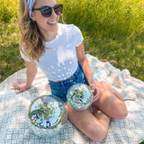 A woman confidently wears a Courtesy of Red, White and Blue headband outdoors, featuring a versatile 3-in-1 twist style for various looks. Designed for comfort and functionality, perfect for workouts or long shifts.