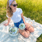 A woman confidently wears a Courtesy of Red, White and Blue headband outdoors, featuring a versatile 3-in-1 twist style for various looks. Designed for comfort and functionality, perfect for workouts or long shifts.