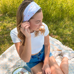 A woman confidently wears the Oh My Stars headband, showcasing its versatile twist style and sweat-absorbent fabric. Designed for function and style, perfect for workouts or play days.