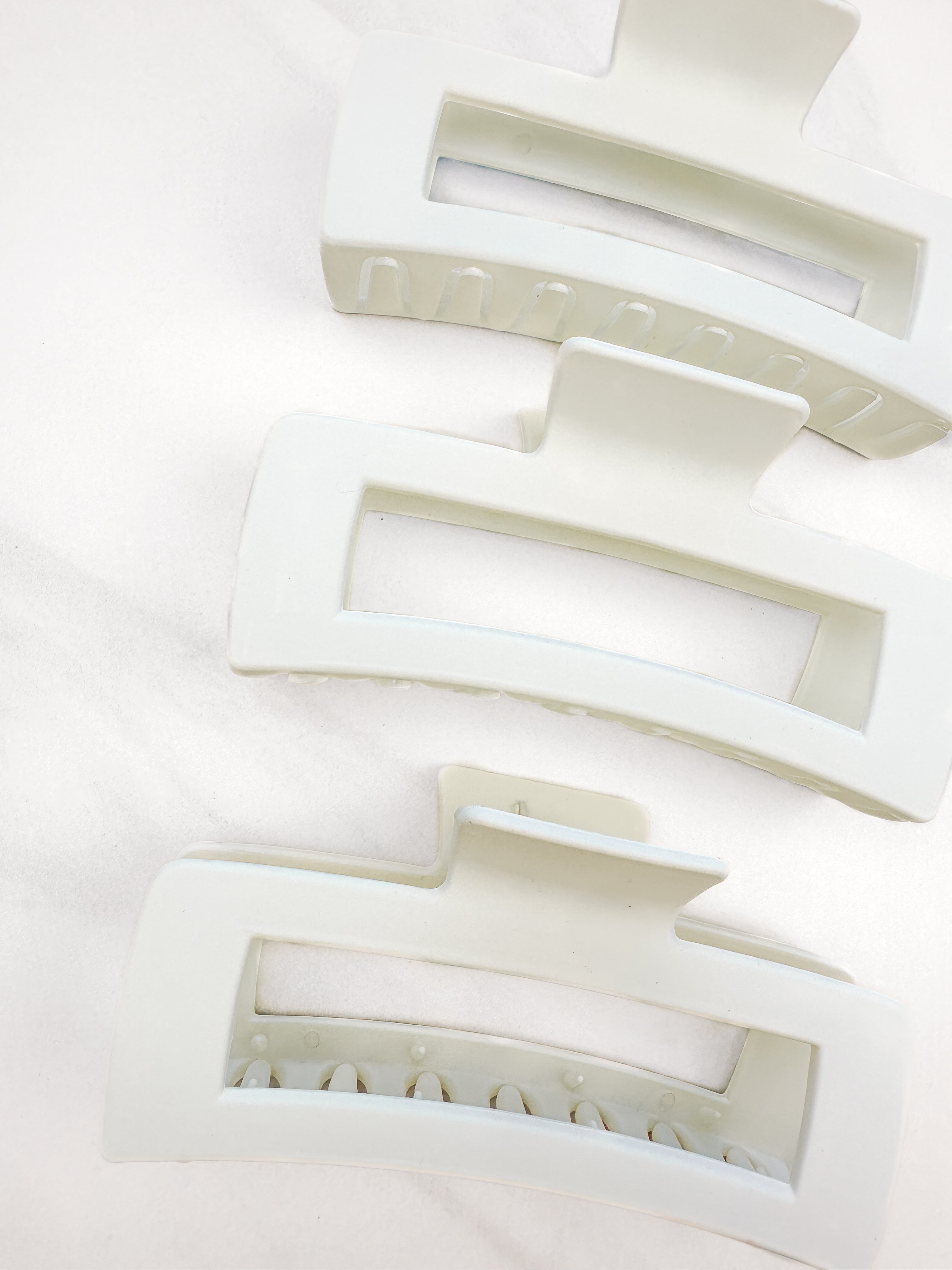 A close-up of the white XL Essential Lilac Clip, a 4.8-inch matte hair accessory with a hinge closure. Perfect for all hair types.