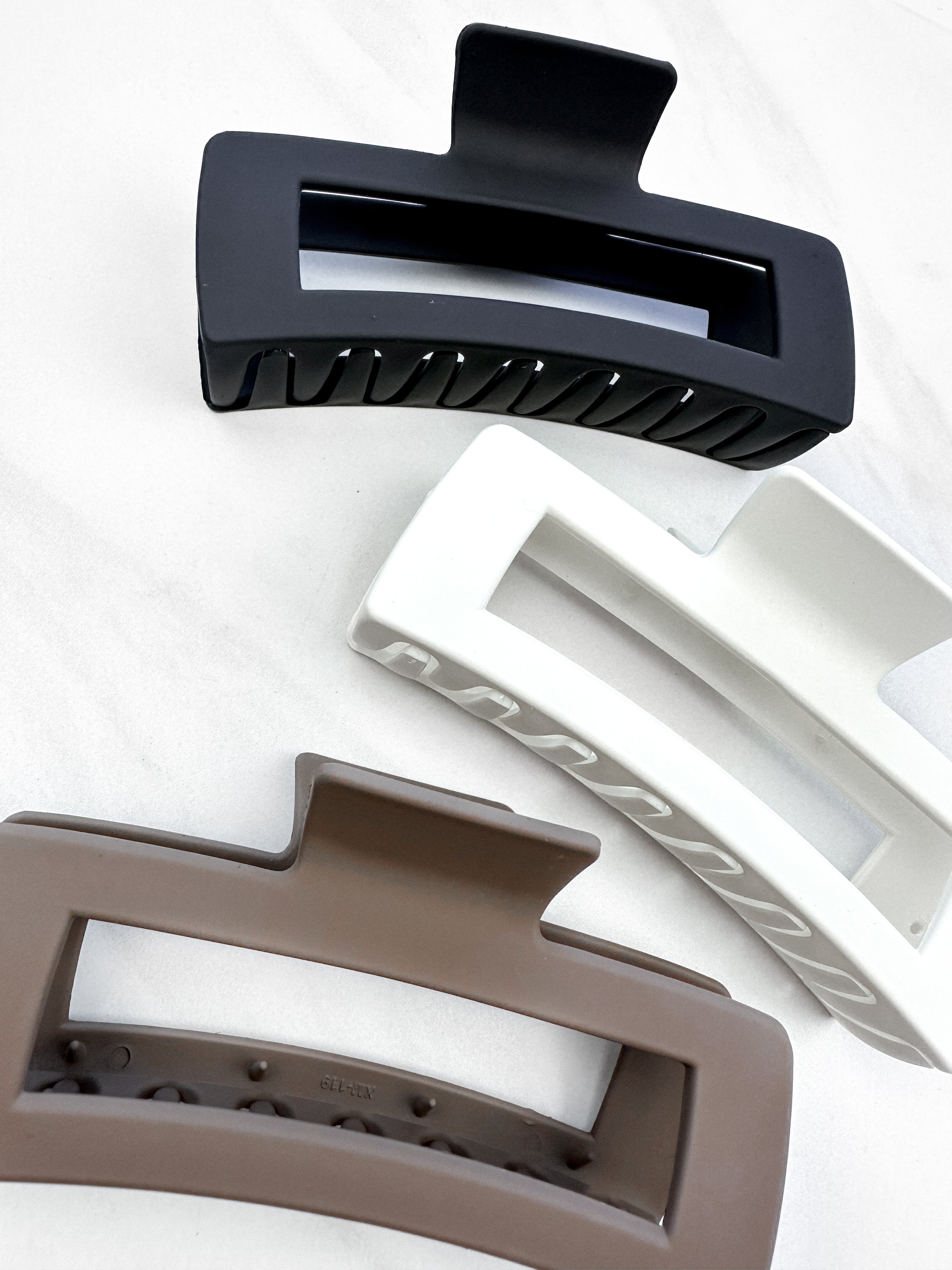 A close-up of a group of XL Essential Lilac Clips, a 4.8-inch matte hair accessory with a hinge closure. Perfect for all hair types.