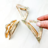 A Different Angle Lilac Clip, a group of green and pink hair clips, perfect for all hair types and textures. 4.5 inches long with a glossy material and hinge closure. Hair-out-of-face approved.