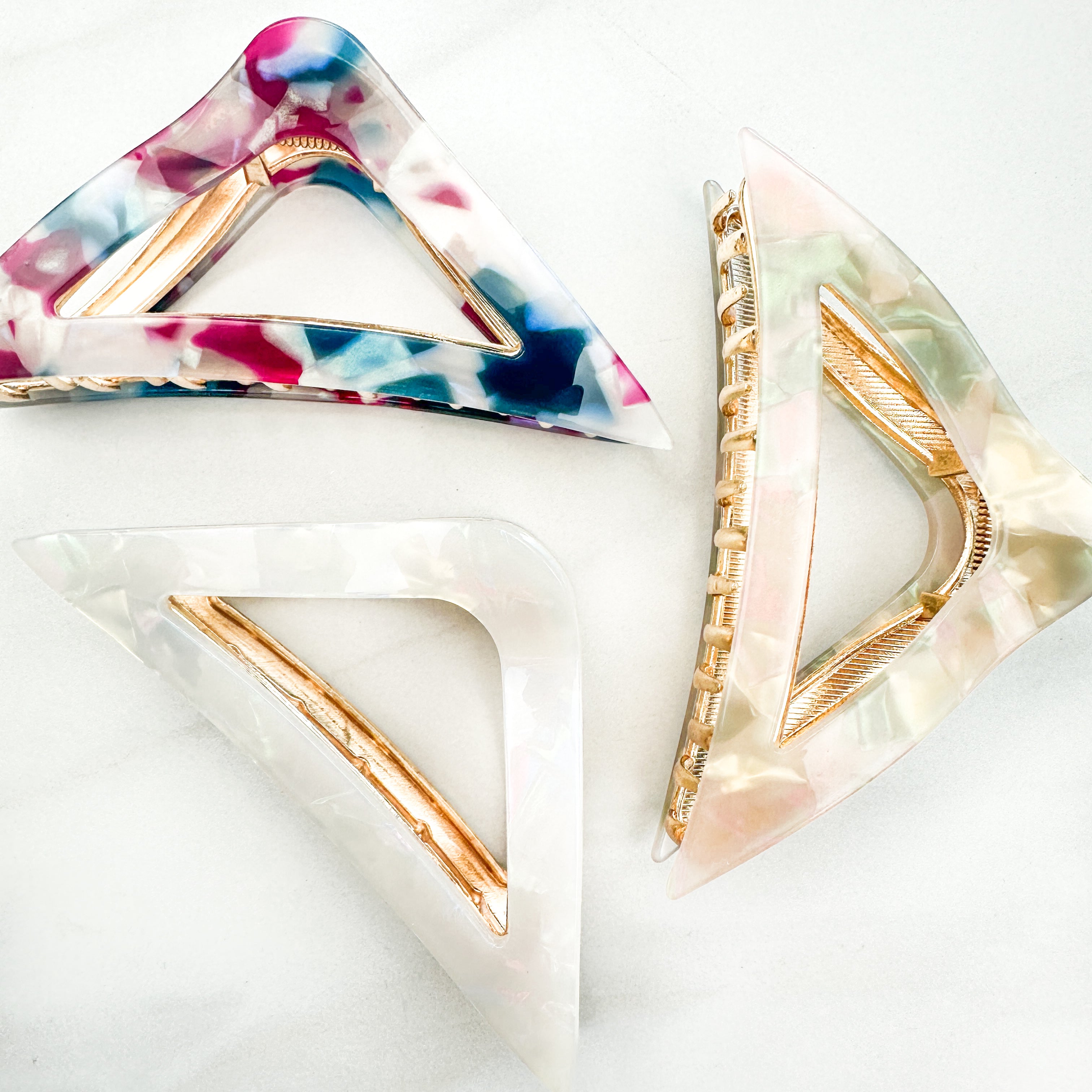 A Different Angle Lilac Clip, a group of multi-colored hair clips, perfect for all hair types and textures. 4.5 inches long with a glossy material and hinge closure. Hair-out-of-face approved.