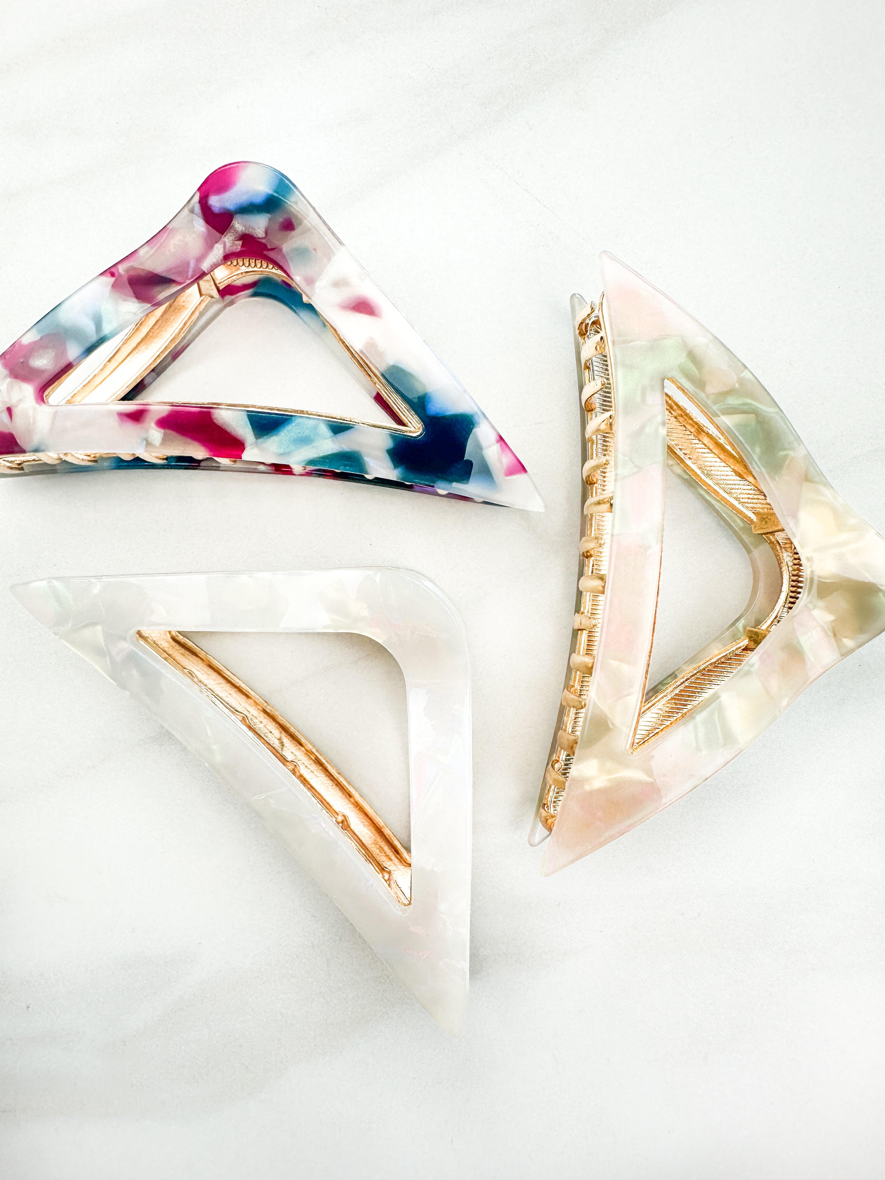 A Different Angle Lilac Clip, a group of multi-colored hair clips, perfect for all hair types and textures. 4.5 inches long with a glossy material and hinge closure. Hair-out-of-face approved.