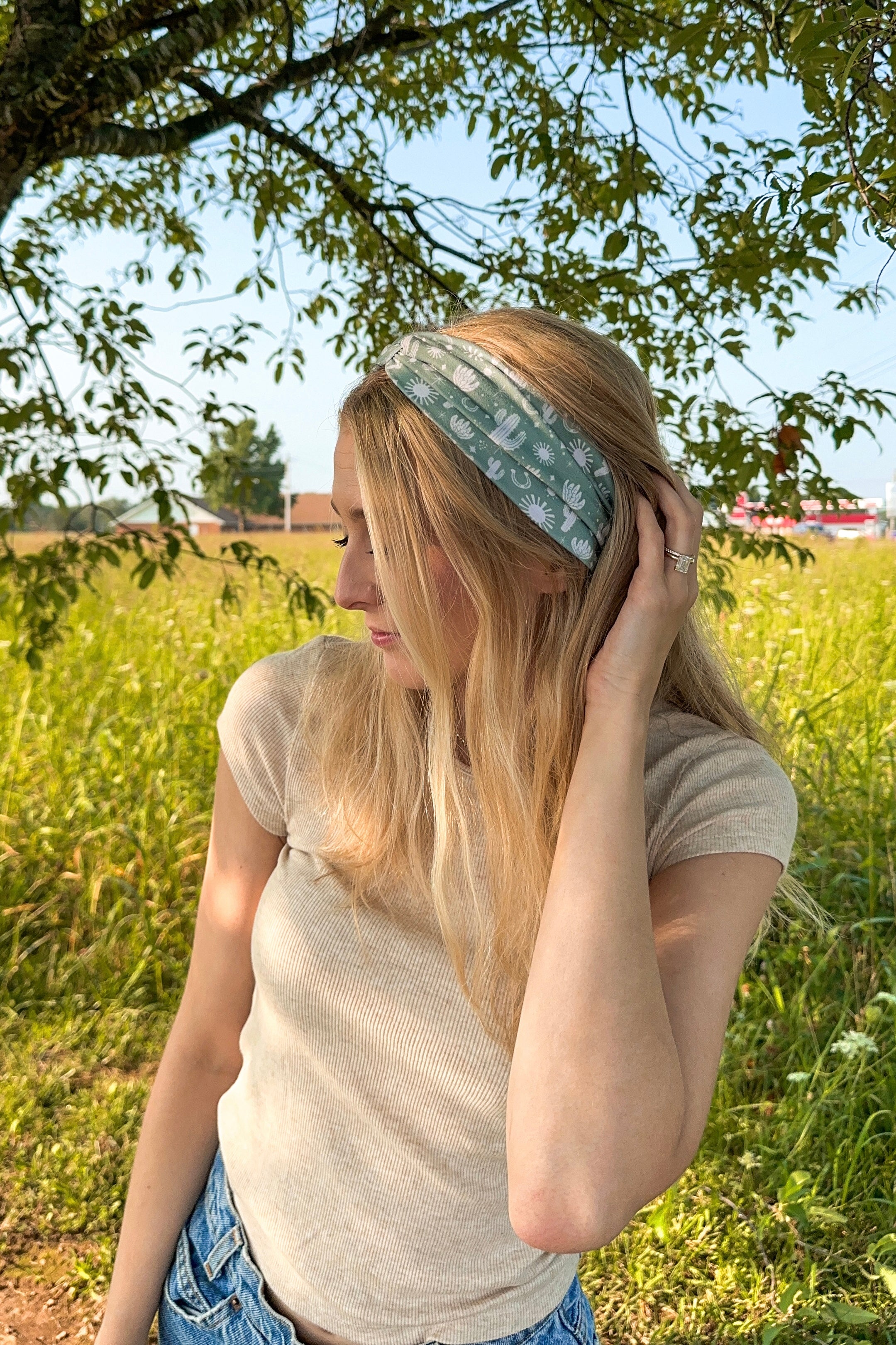 Woman in a field wearing a Keeping It Rural headband, showcasing its versatility and comfort for activities.