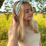 Woman in a field wearing a Keeping It Rural headband, showcasing its versatility and comfort for activities.