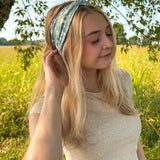 Woman in a field wearing a Keeping It Rural headband, showcasing its versatility and comfort for activities.