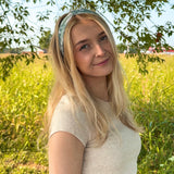 Woman in a field wearing a Keeping It Rural headband, showcasing its versatility and comfort for activities.