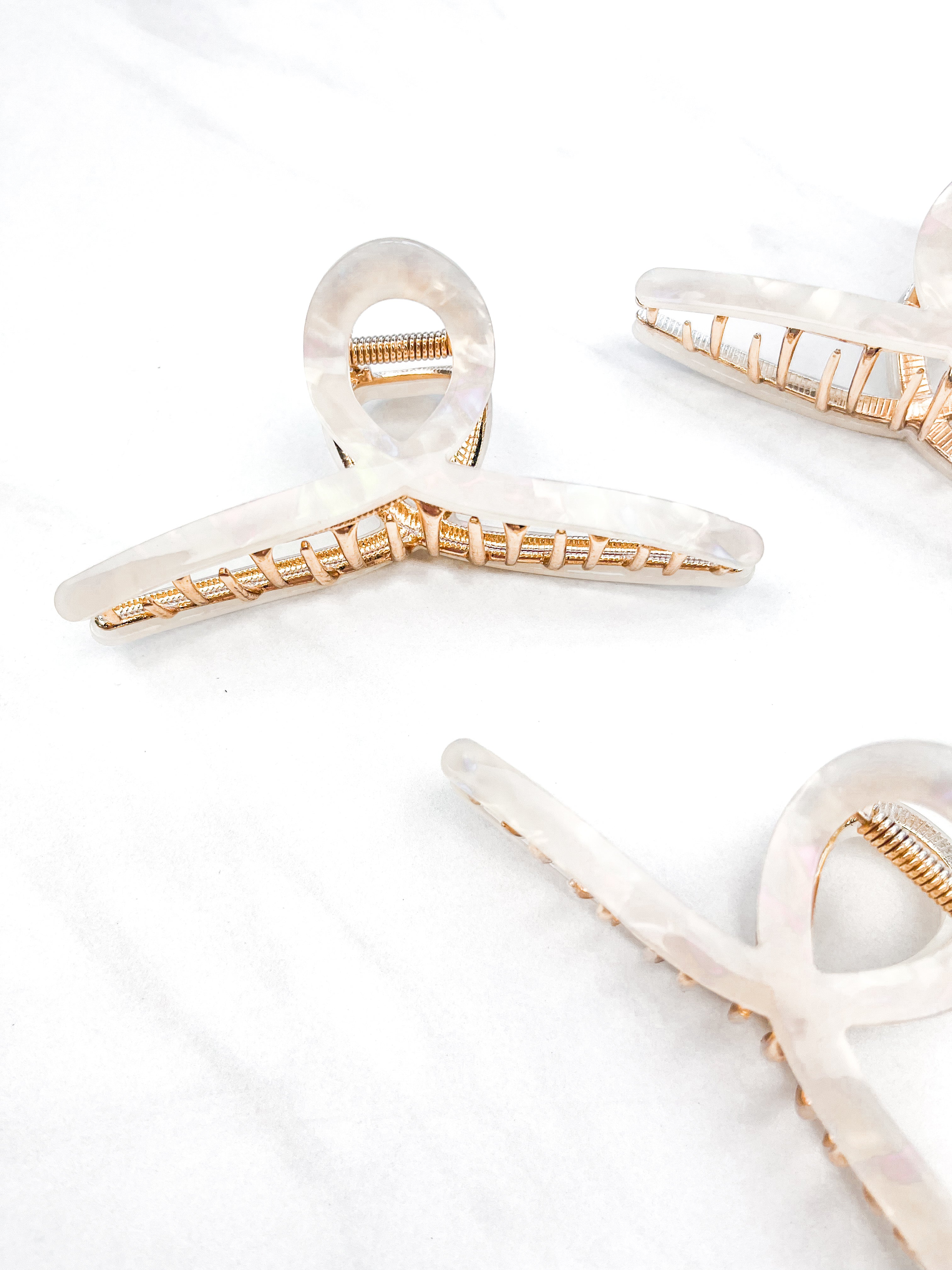 Hair claw clip in marbled white, clear, pink, multi or tortoise in a loop shape