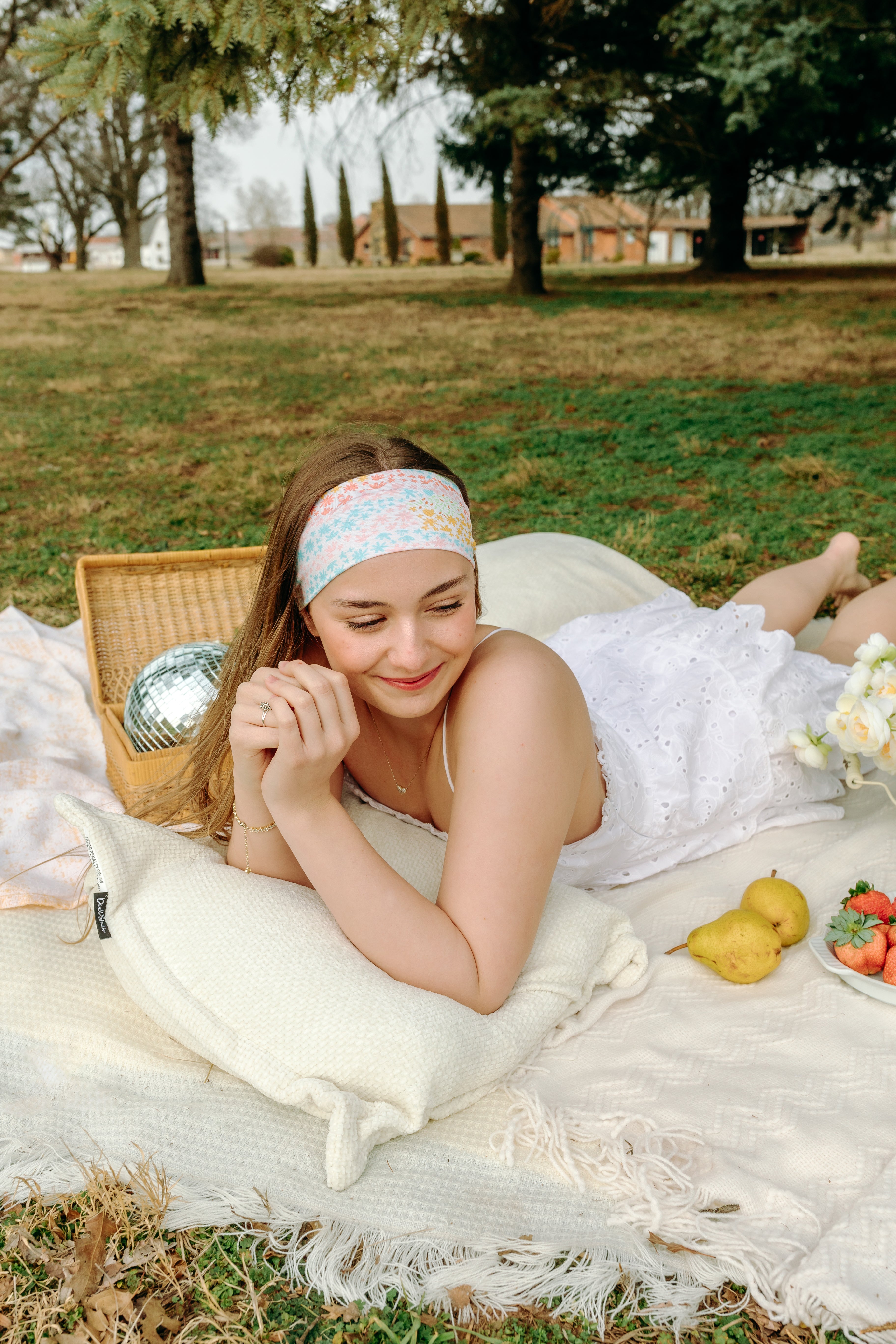 Woman smiling and confidently wearing the Emily Floral on Ivory headband, the perfect non-slip accessory for long shifts or play days.