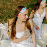 Woman smiling while wearing the Erica Floral on Ivory headband, the perfect non-slip accessory for work or workouts.