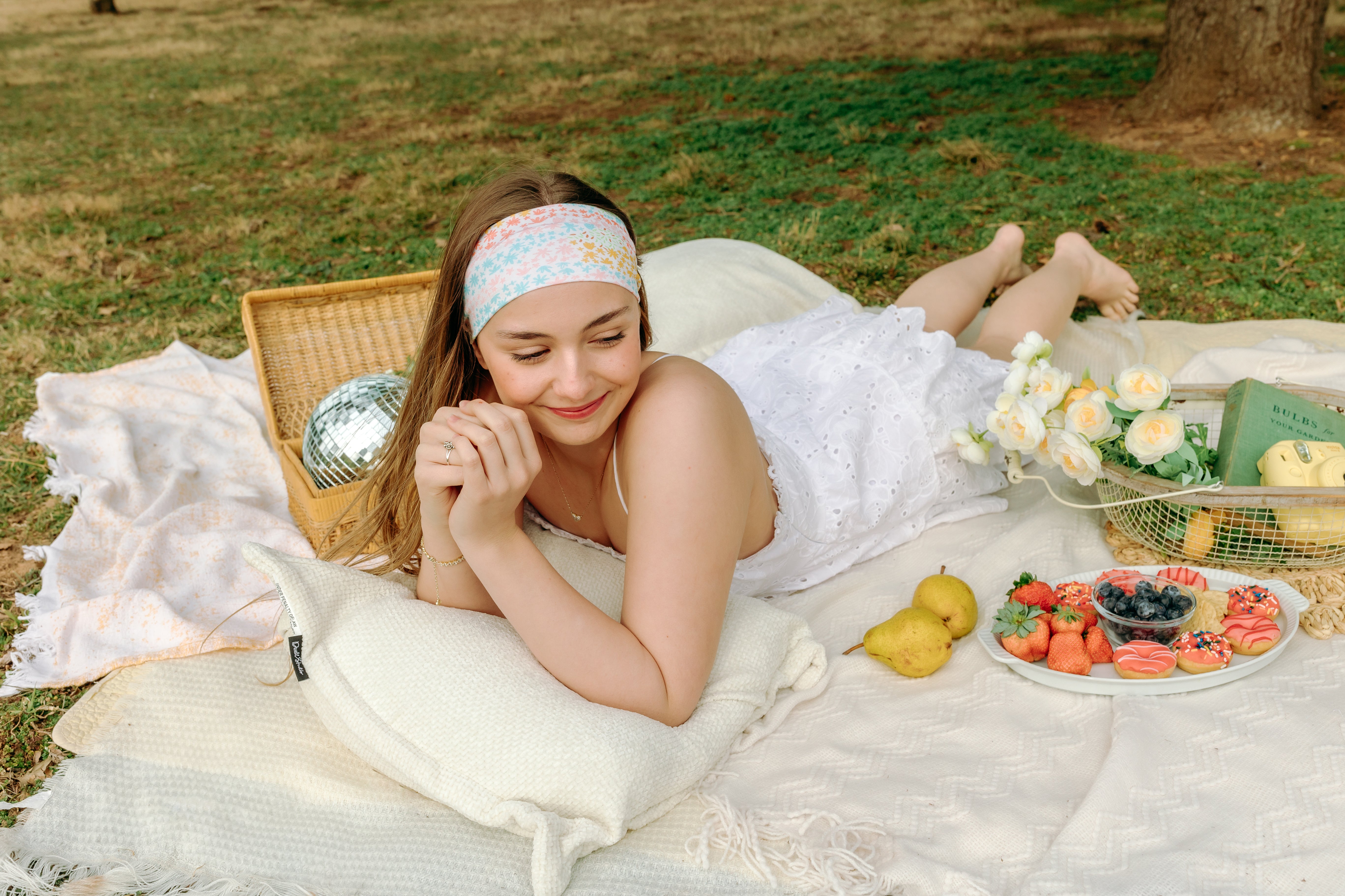 Woman smiling and confidently wearing the Emily Floral on Ivory headband, the perfect non-slip accessory for long shifts or play days.