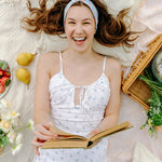 Woman smiling and confidently wearing the Zoey Floral on Sky Blue headband, the perfect non-slip accessory for long shifts or play days.