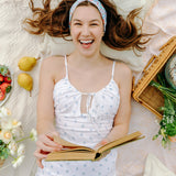 Woman smiling and confidently wearing the Zoey Floral on Sky Blue headband, the perfect non-slip accessory for long shifts or play days.