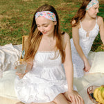 Woman smiling while wearing the Erica Floral on Ivory headband, the perfect non-slip accessory for work or workouts.