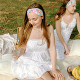 Woman smiling while wearing the Erica Floral on Ivory headband, the perfect non-slip accessory for work or workouts.