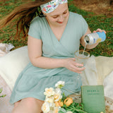 Woman smiling while wearing the Isabella Floral on Ivory headband, the perfect non-slip accessory for work or workouts.