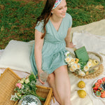 Woman smiling while wearing the Isabella Floral on Ivory headband, the perfect non-slip accessory for work or workouts.