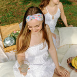 Woman smiling while wearing the Erica Floral on Ivory headband, the perfect non-slip accessory for work or workouts.