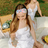 Woman smiling while wearing the Erica Floral on Ivory headband, the perfect non-slip accessory for work or workouts.