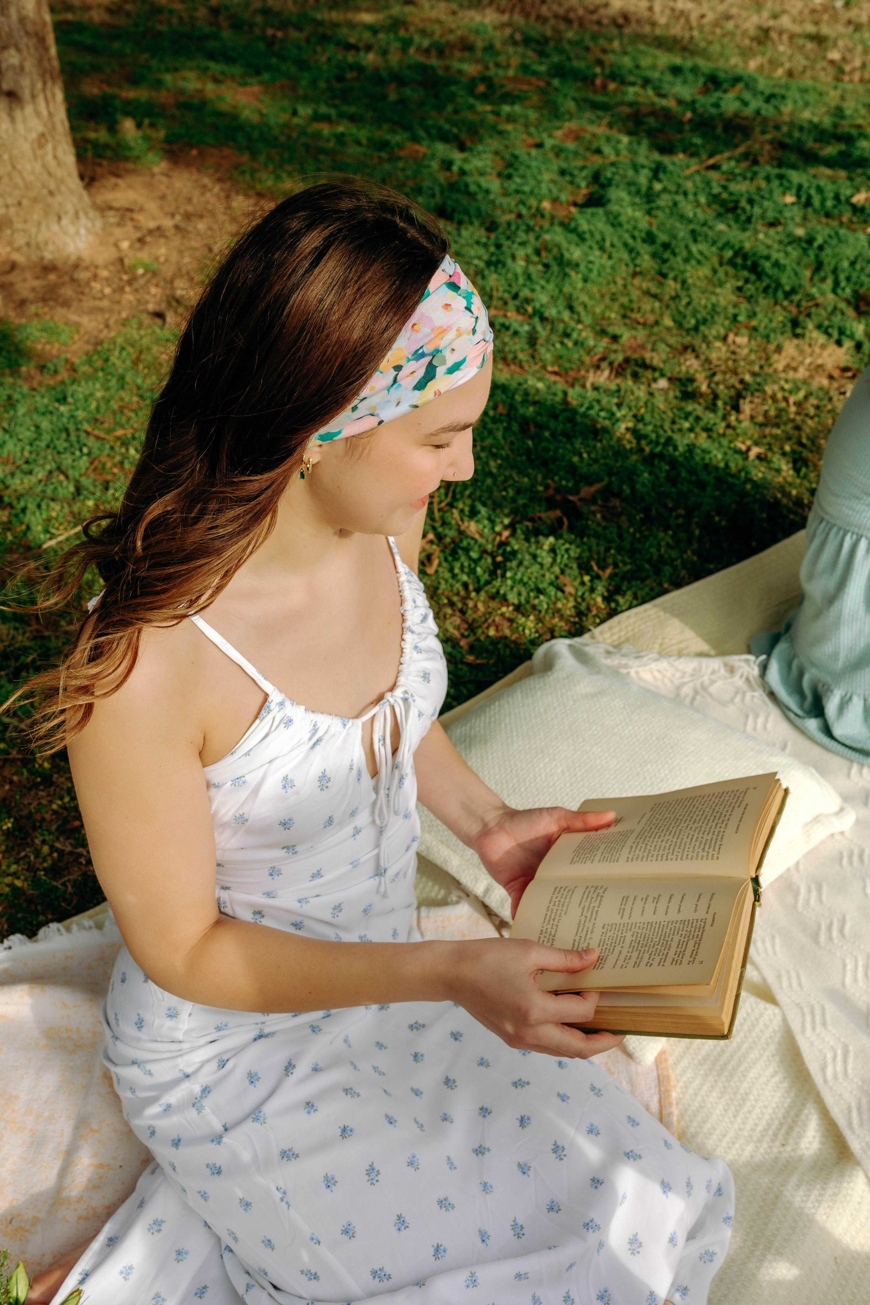 Woman with long hair confidently wearing the Tori Floral on Sage headband, the perfect non-slip accessory for long shifts or play days.