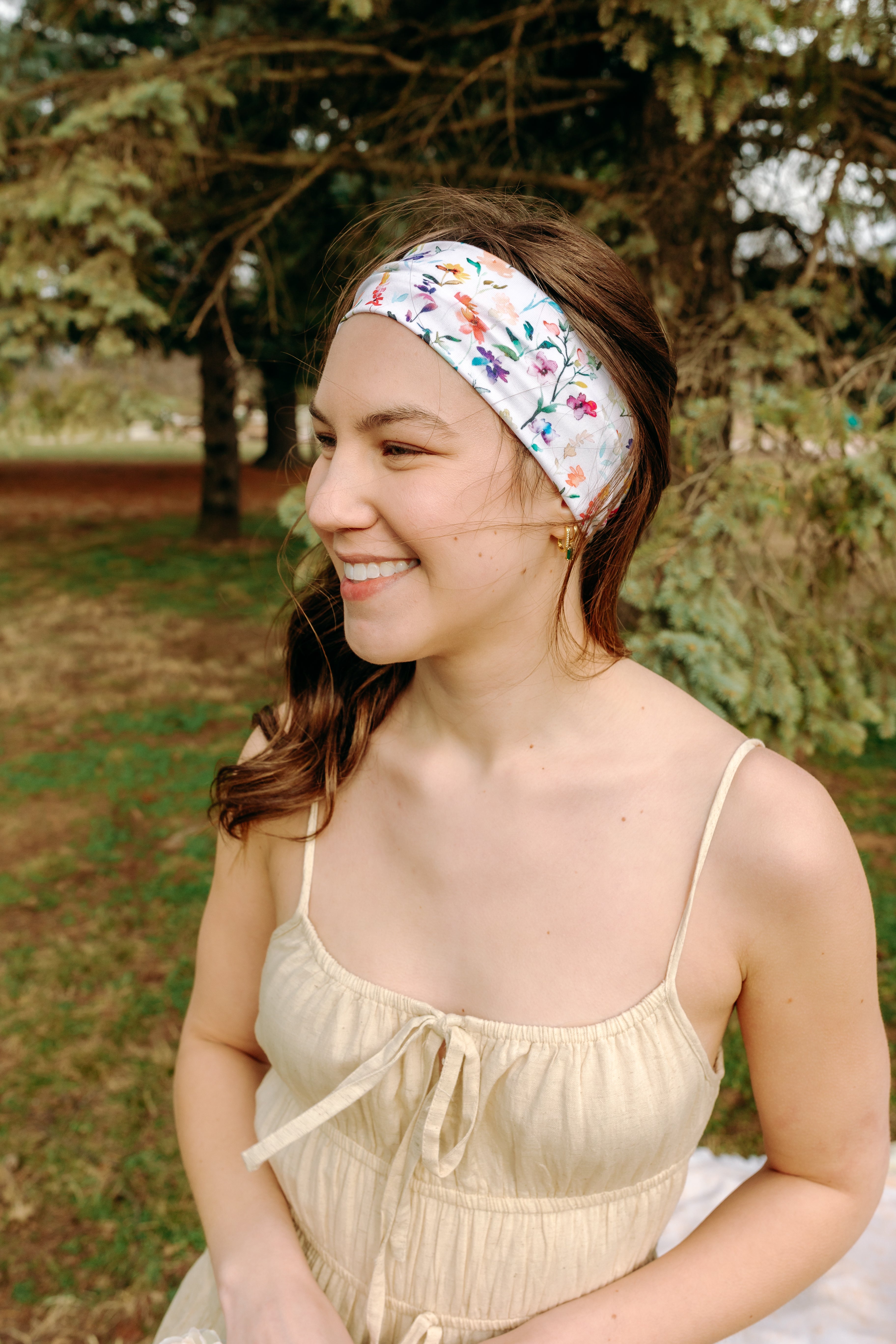 Woman with long hair confidently wearing the Willow Floral on Ivory headband, the perfect non-slip accessory for long shifts or play days.
