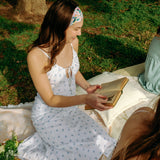 Woman with long hair confidently wearing the Tori Floral on Sage headband, the perfect non-slip accessory for long shifts or play days.