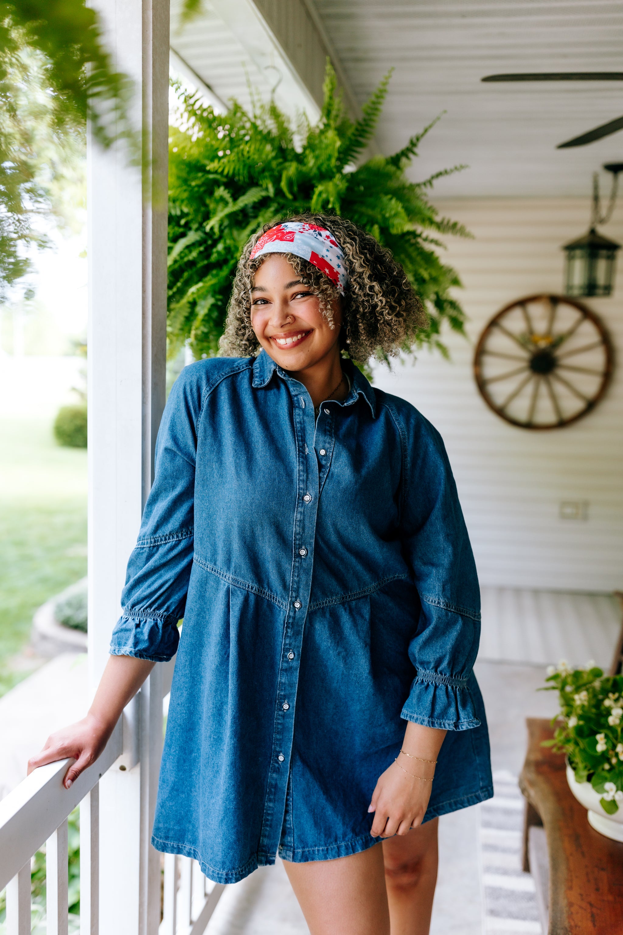 Woman with curly hair type happily wearing the most comfortable hand-made headband in the print You Look Like the Fourth of July.