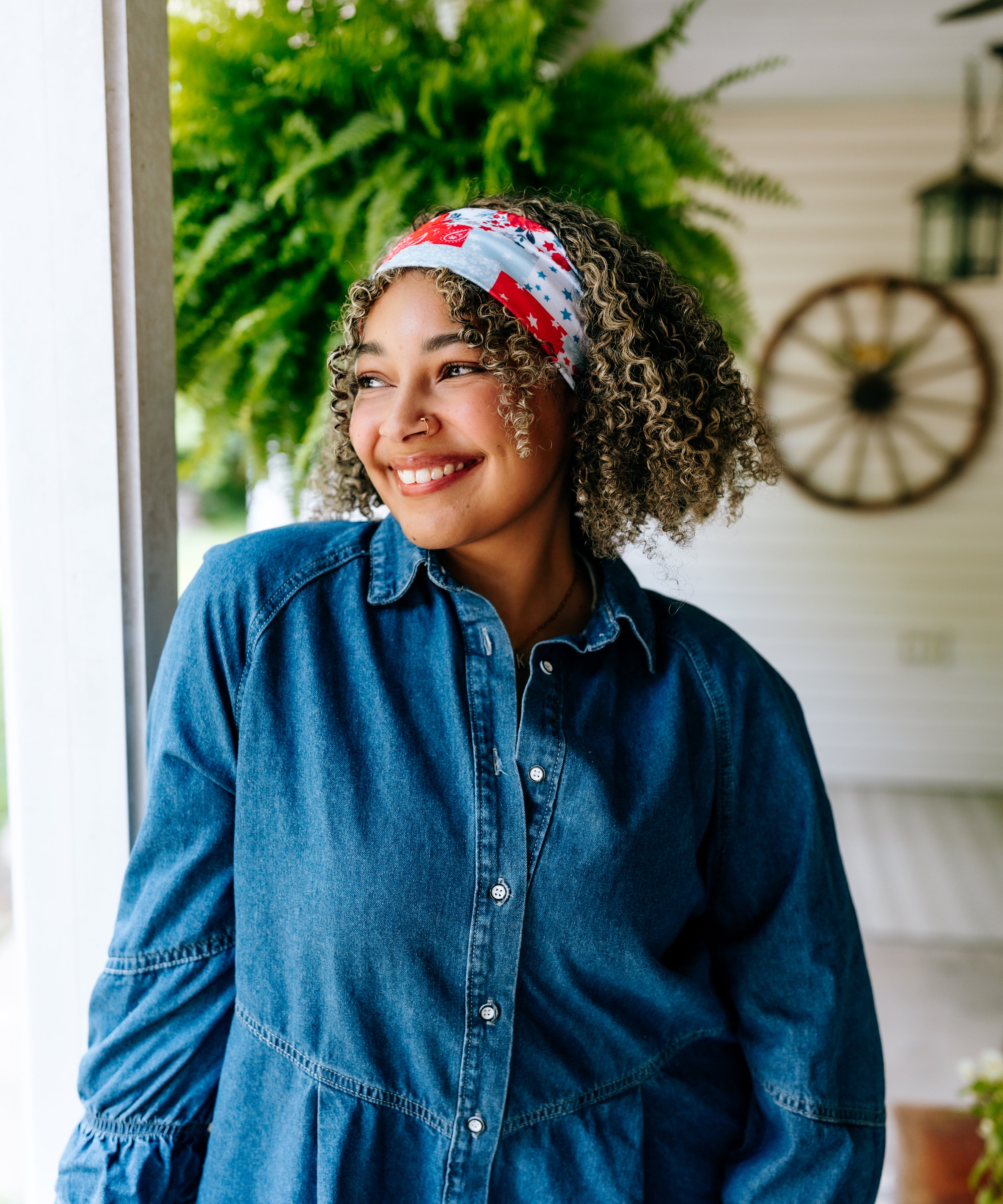 Woman with curly hair type happily wearing the most comfortable hand-made headband in the print You Look Like the Fourth of July.
