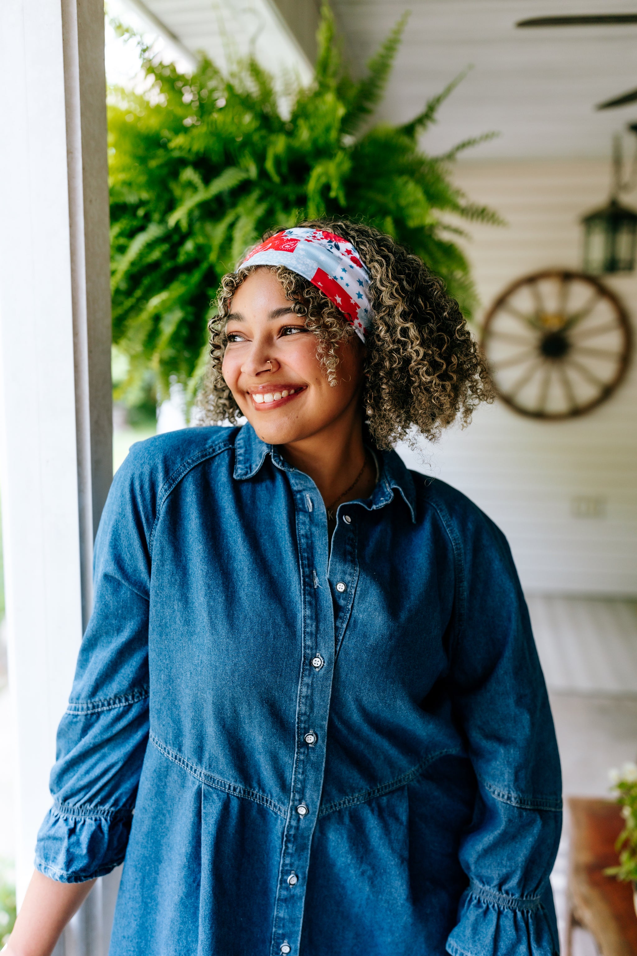 Woman with curly hair type happily wearing the most comfortable hand-made headband in the print You Look Like the Fourth of July.