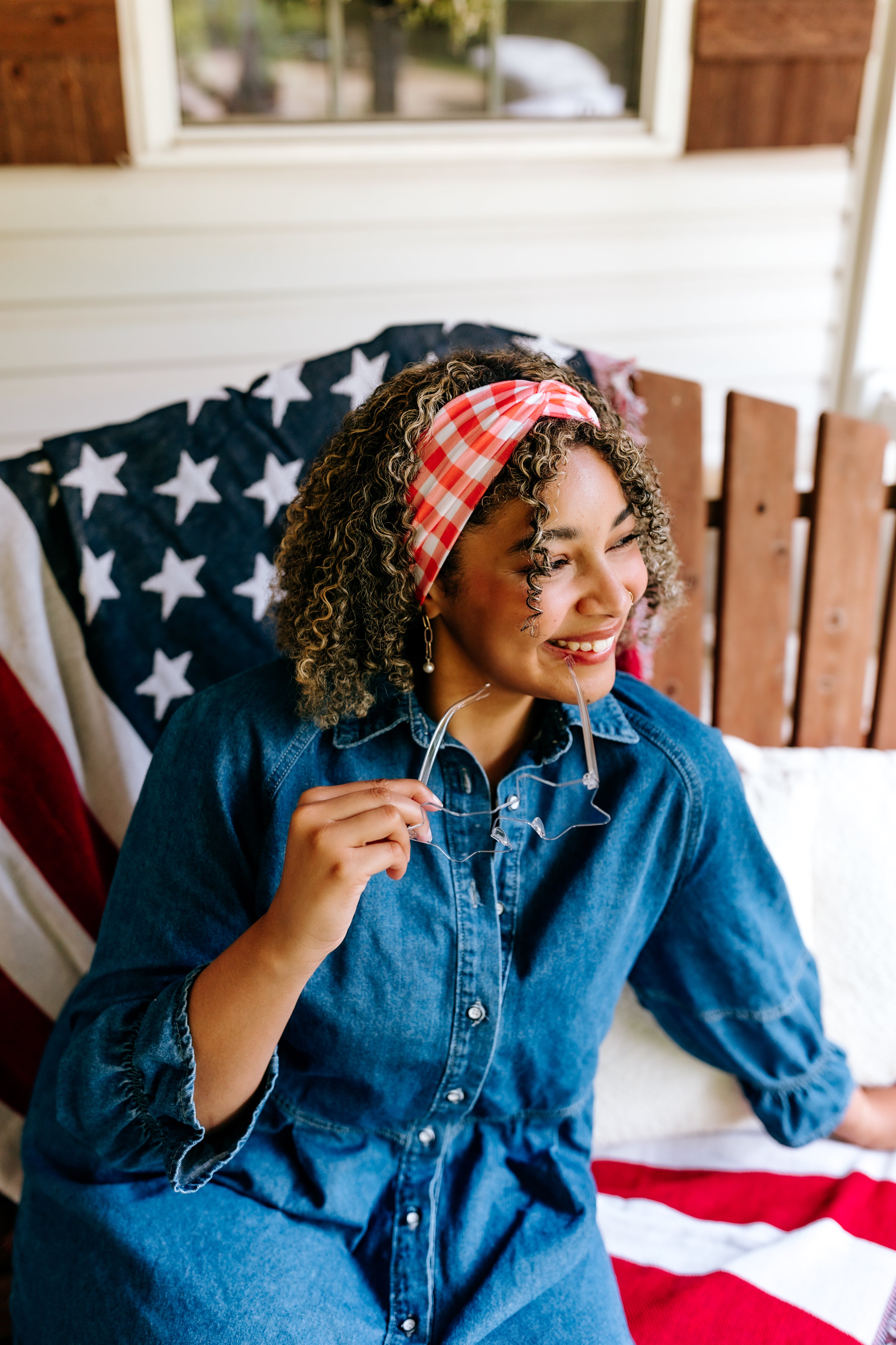 Woman with curly hair type happily wearing the most comfortable hand-made headband in the print More Picnics, Please!