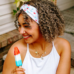 Woman with curly hair type happily wearing the most comfortable hand-made headband in the print Stay Cool. 