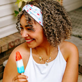 Woman with curly hair type happily wearing the most comfortable hand-made headband in the print Stay Cool. 