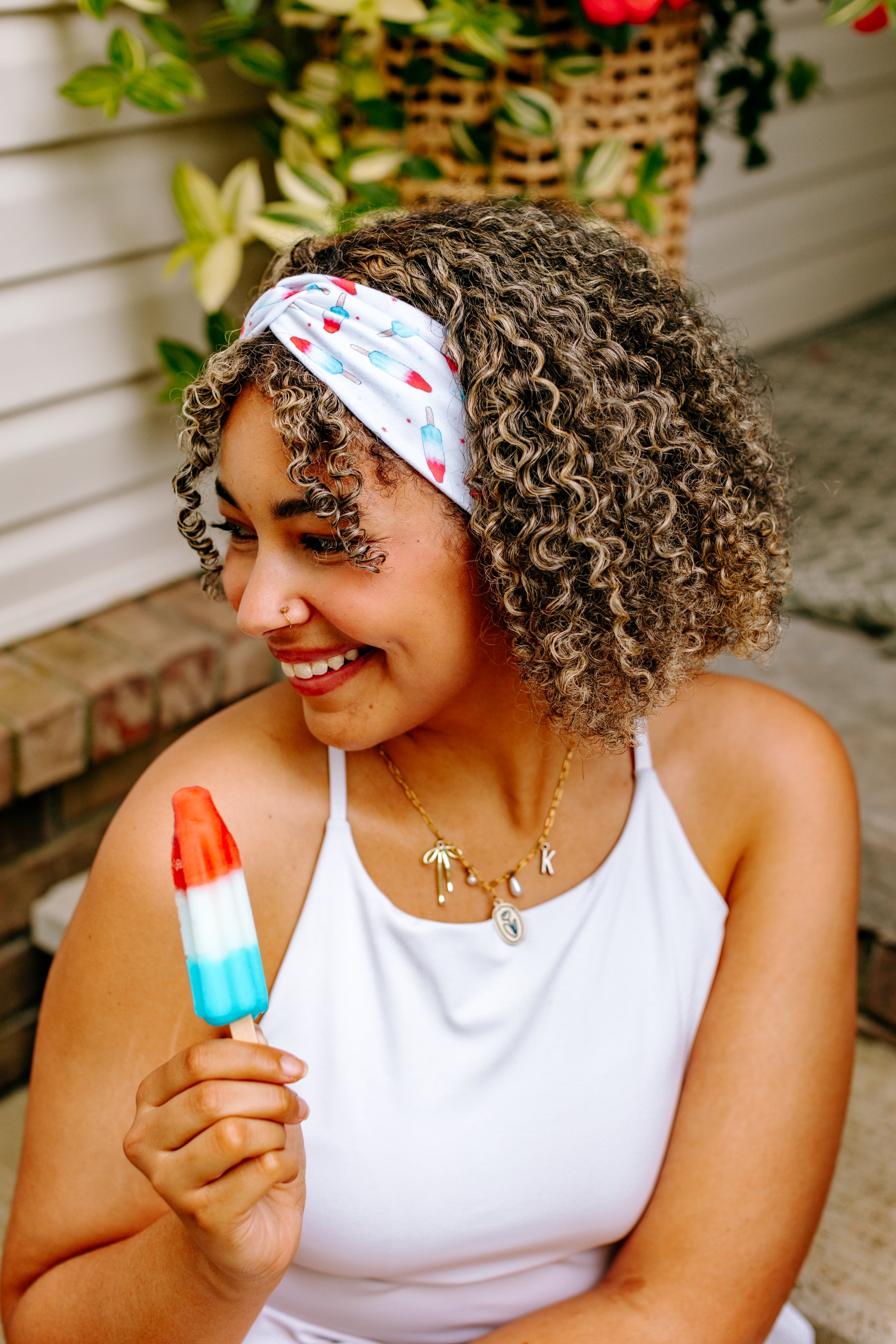 Woman with curly hair type happily wearing the most comfortable hand-made headband in the print Stay Cool. 