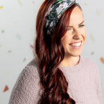 A black headband with white floral pattern and "Mama" script, offering confidence and functionality. Features one size fits most, machine washable, ultra stretchy poly-knit blend, versatile 3-in-1 twist style, sweat absorbent double-layer fabric.