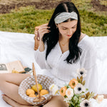Woman with long hair happily wearing the most comfortable hand-made headband in the print Wren Floral.