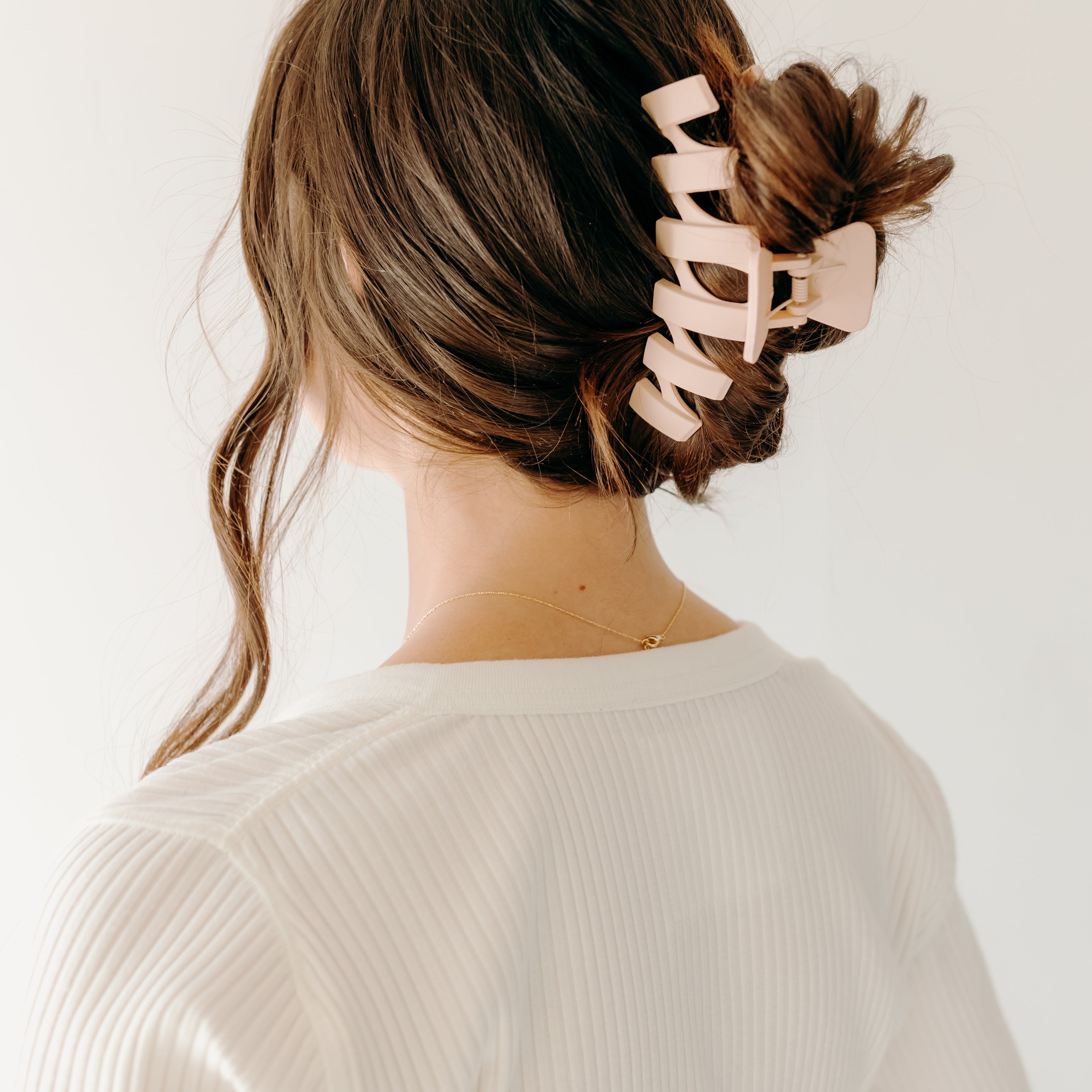 A woman with long hair showcasing the Simply Twisted Lilac Clip. Matte material, 5.5 inches long, with a hinge closure.