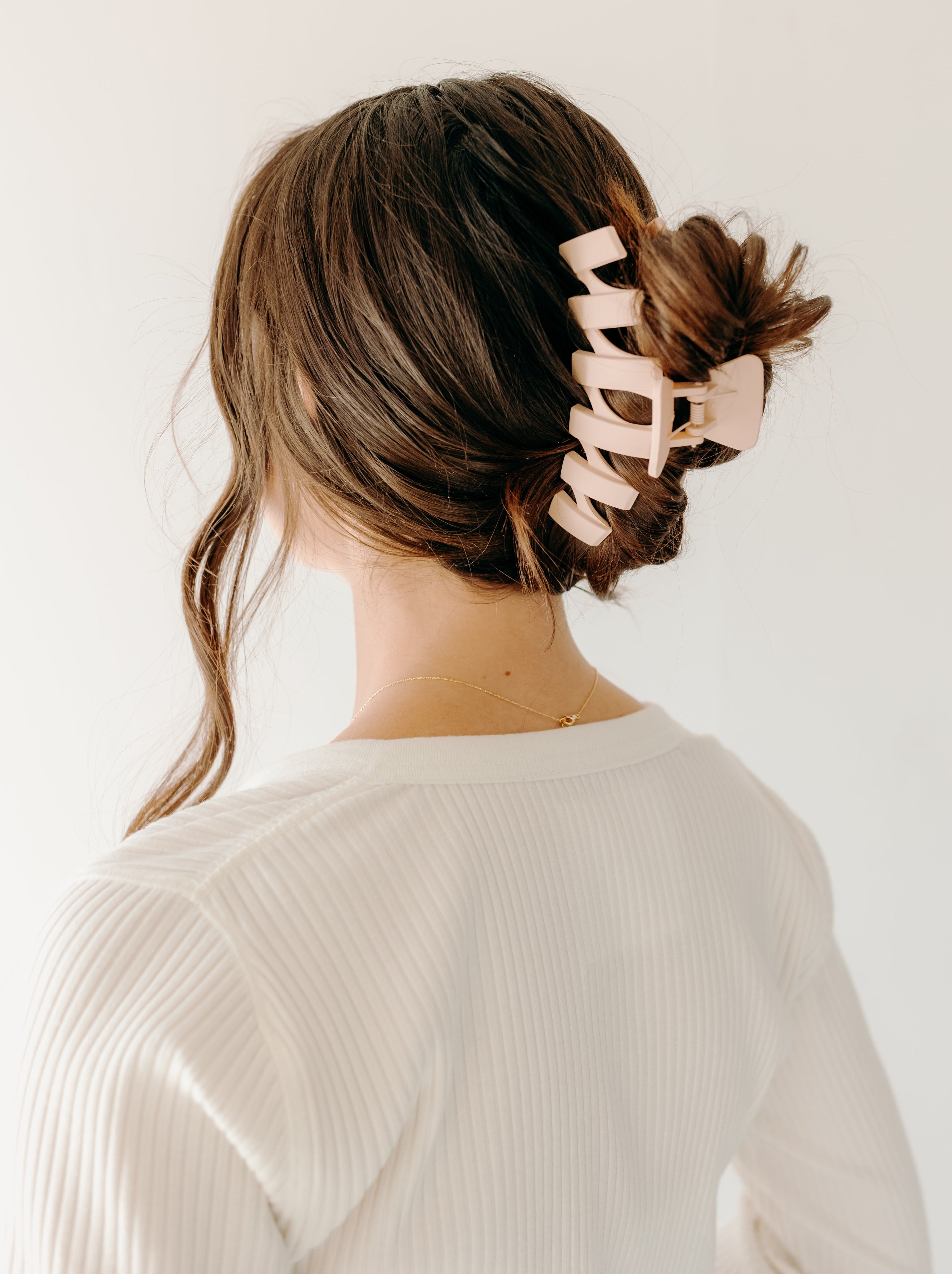 A woman with long hair showcasing the Simply Twisted Lilac Clip. Matte material, 5.5 inches long, with a hinge closure.