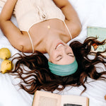 Woman with long hair happily wearing the most comfortable hand-made headband in the print Dottie on Emerald.