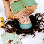Woman with long hair happily wearing the most comfortable hand-made headband in the print Dottie on Emerald.